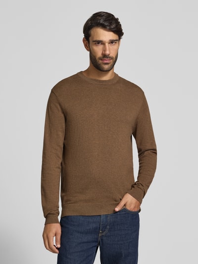 Męski model nosi Regular Fit Strickpullover aus Baumwoll-Mix mit Kaschmir-Anteil od Casual Friday w kolorze brązowym, dzianinowa struktura, długie rękawy, okrągły dekolt, ściągacze, długość pleców w rozmiarze M: 70 cm, długość rękawa: 51 cm; widok całej sylwetki z przodu.