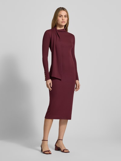 Frauenmodel trägt Midikleid mit Stehkragen Modell 'STANCIO' von Lauren Ralph Lauren, bordeauxrot, figurbetont, Ganzkörperansicht von vorne. Baumwoll-Mix mit Modal-Anteil, knielang, lange Ärmel.