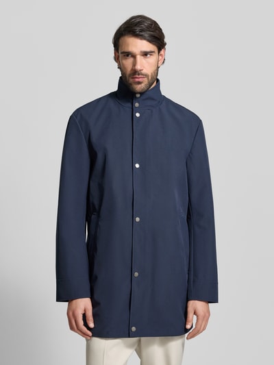 Männermodel trägt Regular Fit Mantel mit Stehkragen von Christian Berg Men in Dunkelblau, Elastischer-Material-Mix, Eingrifftaschen, Knopfleiste, Ganzkörperansicht von vorne.