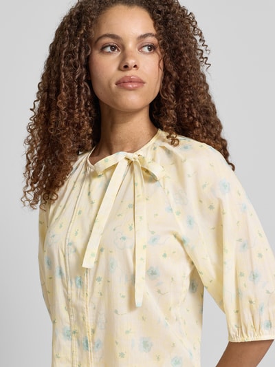 Frauenmodel trägt Bluse mit Rundhalsausschnitt und Binde-Detail von JAKE*S STUDIO WOMAN in zartem Gelb mit floralem Muster, Reine Baumwolle, Gerader Schnitt, verdeckte Knopfleiste, 3/4-Arm, Nahaufnahme Oberkörper.