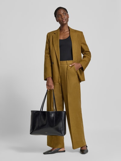 Frauenmodel trägt Shopper mit Label-Detail von CK Calvin Klein in glänzendem Schwarz, kombiniert mit braunem Anzug, Ganzkörperansicht von vorne, Damen Shopper von CK Calvin Klein.