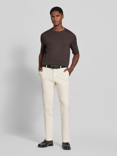 Mannelijk model draagt Slim Fit Chino uit katoenmix model 'Kaiton1' van BOSS, Heren broek, crèmekleur met rechte pijpen, volledig frontaal, volledige lichaamsopname van voren.