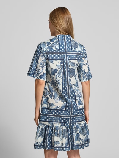 Frauenmodel trägt Knielanges Tunikakleid mit 1/2-Arm von Christian Berg Woman, Reine Baumwolle, Straight Fit, Muster in Blau und Weiß, Knielänge, Tunikakragen, Rückenlänge 88 cm, Brustweite 48 cm, Ärmellänge 30 cm, Ganzkörperansicht Rückansicht.