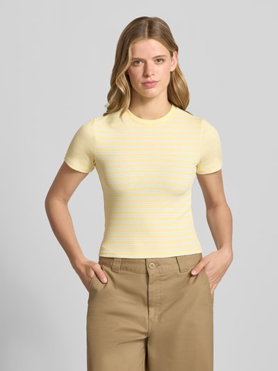 Frauenmodel trägt Slim Fit T-Shirt mit Viskose-Anteil Model: 'LUPE' von ONLY, gelb-weiß gestreift, Damen T-Shirt, Ganzkörperansicht von vorne.