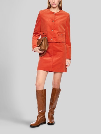 Frauenmodel trägt Regular Fit Blazer aus Cord mit Rundhalsausschnitt von Marc Cain in Orange, Pattentaschen, Knopfleiste, reine Baumwolle, Ganzkörperansicht von vorne.