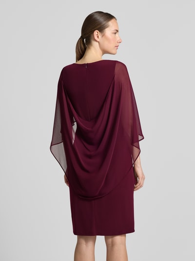 Frauenmodel trägt Tailliertes Cocktailkleid mit Strasssteinbesatz von Vera Mont in Dunkelrot, feine Transparenz, glatte Struktur, Ganzkörperansicht Rückansicht, Damen Cocktailkleid von Vera Mont.