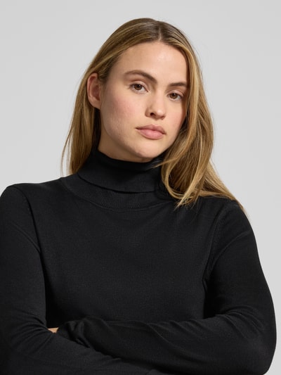 Frauenmodel trägt Longsleeve aus Viskose-Mix Modell 'MAFA' von ICHI, eng anliegende Passform, Rollkragen, Ripp-Optik, Nahaufnahme Oberkörper.