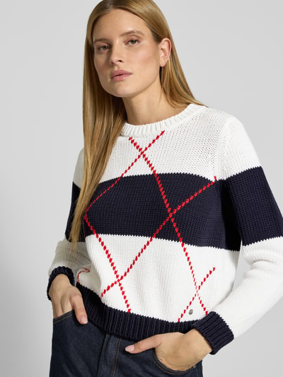 Frauenmodel trägt Strickpullover mit Rautenmuster und Rundhalsausschnitt von monari aus Baumwoll-Mix in Dunkelblau, Weiß, Rot, Regular Fit, Nahaufnahme Oberkörper.