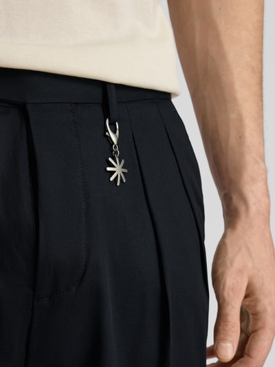 Männermodel trägt Hose mit gelegten Falten und Eingrifftaschen von Manuel Ritz, dunkler Baumwoll-Mix mit Stretch-Anteil, Nahaufnahme Hüfte.