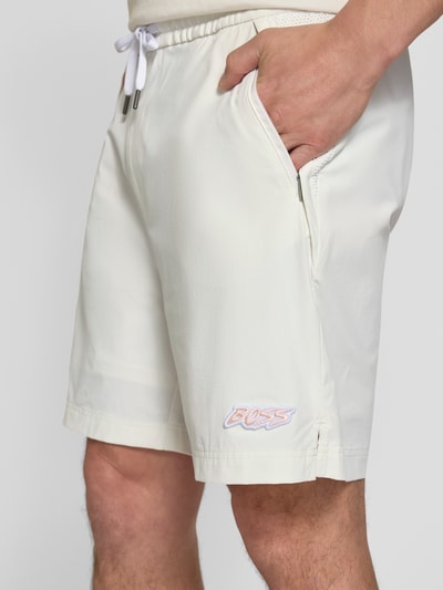 Männermodel trägt Relaxed Fit Sport-Shorts mit seitlichen Reißverschlusstaschen Modell 'Fisher' von BOSS Orange in Unifarben mit Tunnelzug, Elastisch und Reißverschlusstaschen, Nahaufnahme Oberkörper.