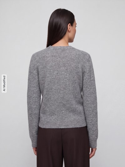 Frauenmodel trägt graue Regular Fit Strickjacke mit Woll-Anteil Modell 'MALOU' von PIECES, Ganzkörperansicht Rückansicht, KI-modifiziertes Bild.