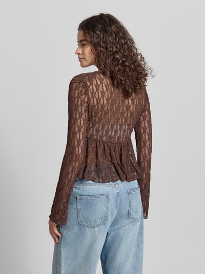 Frauenmodel trägt Shaped Fit Blusentop mit Bindeverschluss Modell 'LAYA' von Only in Brauntönen, semitransparente Mesh-Optik, abstraktes Muster, langarm, ohne Kragen, Taillengürtel zum Binden, Materialverarbeitung: Mesh, Ganzkörperansicht Rückansicht.