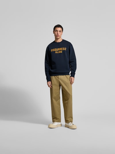 Männermodel trägt Cool Fit Sweatshirt aus reiner Baumwolle von Dsquared2, dunkelblau mit Label-Print, elastische Abschlüsse, Ganzkörperansicht von vorne.