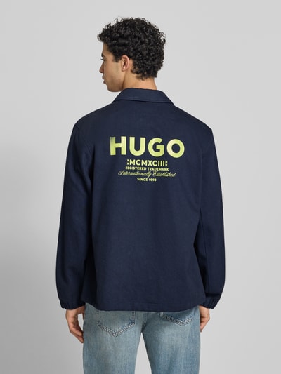 Männermodel trägt Regular Fit Hemdjacke aus reiner Baumwolle Modell 'BIYO' von HUGO in Dunkelblau, Optik: Unifarben, Twill, Ganzkörperansicht Rückansicht.