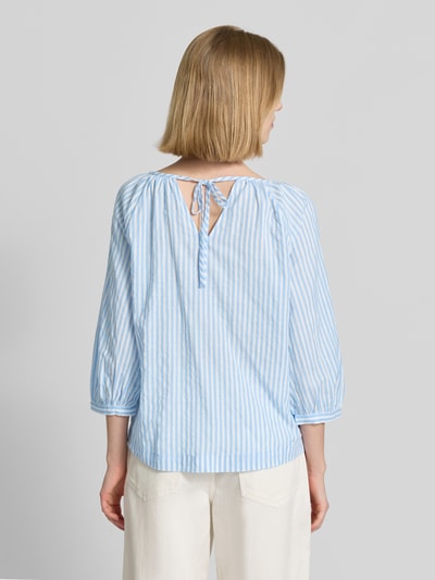 Frauenmodel trägt Relaxed Fit Bluse aus Baumwoll-Viskose-Mix von s.Oliver RED LABEL mit blau-weißem Streifenmuster, 3/4-Ballonärmel, U-Boot-Ausschnitt, Bindeband am Rücken, Ganzkörperansicht Rückansicht.