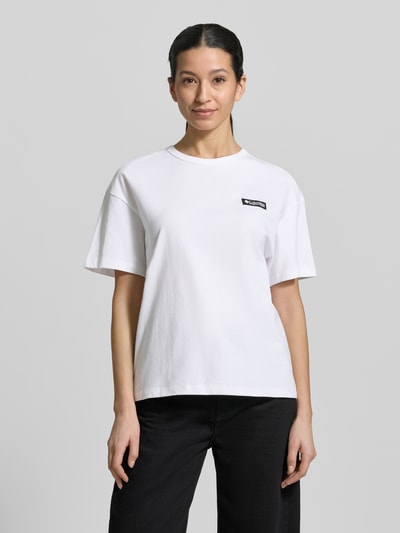 Modelka nosi T-shirt aus reiner Baumwolle mit Modell 'CSC™' od Columbia, damski t-shirt, luźny krój, okrągły dekolt, krótki rękaw, nadruk z logo, technologia Omni-Shade UPF 30, długość tyłu w rozmiarze S: 60 cm, biały kolor, gładka faktura, całkowity widok z przodu.