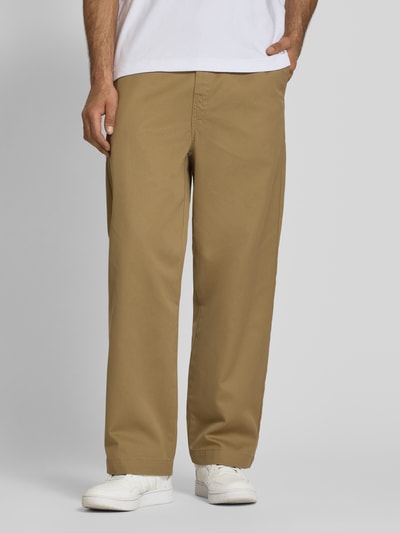 Männermodel trägt Hose mit Gesäßtaschen Modell 'Denison' von Carhartt Work In Progress in Beige, Material-Mix, Relaxed-Fit, Nahaufnahme Unterkörper.