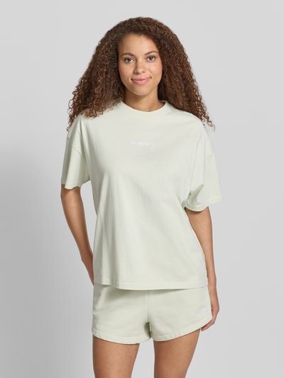 Frauenmodel trägt Oversized Damen T-Shirt mit Label-Stitching Modell 'BRACY' von Pegador in hellgrün aus Reine Baumwolle, Rundhalsausschnitt, Rückenlänge bei Größe S 62 cm, Ganzkörperansicht von vorne.