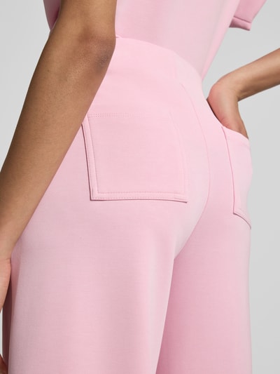 Frauenmodel trägt Sweatpants mit elastischem Bund von Rich & Royal in Rosa, Wide Fit, Gesäßtaschen, Modal-Mix, Detailaufnahme Rückansicht.