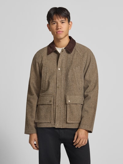 Männermodel trägt Barn Jacket mit Pattentaschen Modell 'SALAMANCO' von JACK & JONES in Braun mit Cord-Kentkragen, Ganzkörperansicht von vorne.