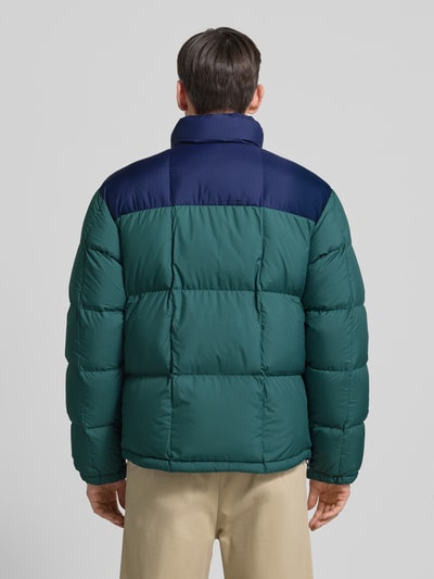 Męskimodel nosi Kurtka puchowa z zamkiem błyskawicznym dwustronnym i stójką od Polo Ralph Lauren, wypełnienie puchem i pierzem, krój regular fit, wyhaftowane logo, kolor zielony z granatowym, kieszeń na piersi, długość tyłu 73 cm, szerokość ramion 50 cm, szerokość klatki piersiowej 57 cm, długość rękawów 70 cm, całkowity widok z tyłu.