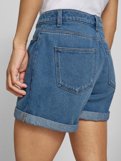 Frauenmodel trägt Regular Fit Shorts im 5-Pocket-Design Modell 'Miley' von Noisy May aus Reine Baumwolle, blauer Denim, Ganzkörperansicht Rückansicht.