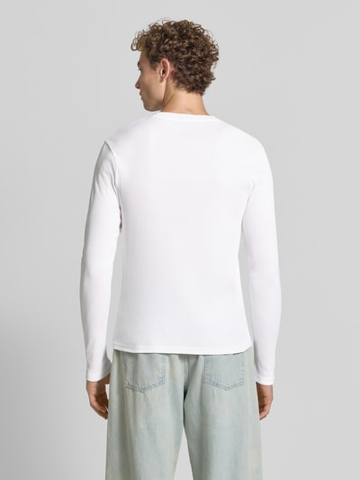 Männermodel trägt Slim Fit Longsleeve aus reiner Baumwolle Modell 'Enil' von DRYKORN in Weiß, Strukturmuster, Ganzkörperansicht Rückansicht.