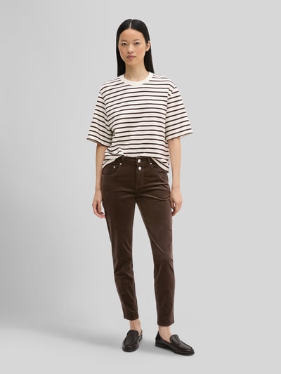 Frauenmodel trägt Boyfriend Fit Cordhose aus Baumwoll-Mix von Marc O'Polo in Braun, Damen Cordhose, weiße Wand, Ganzkörperansicht von vorne.