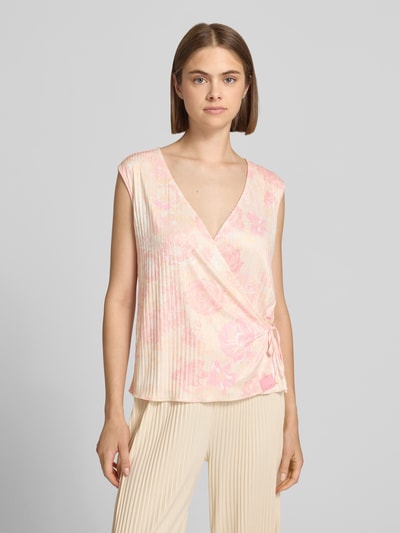 Frauenmodel trägt Blusentop in Wickel-Optik Modell 'Solin' von OH APRIL in zartem Rosa mit floralen Mustern, Material-Mix, Nahaufnahme Oberkörper.