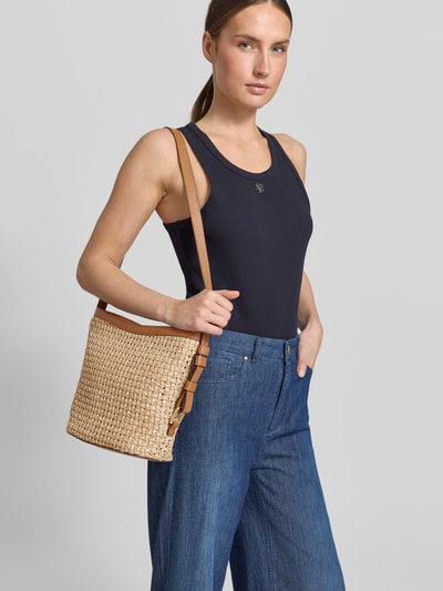 Frauenmodel trägt Handtasche mit Schulterriemen Modell 'COSMO' von Abro, geflochtene Struktur, Reißverschluss, Nahaufnahme Oberkörper.