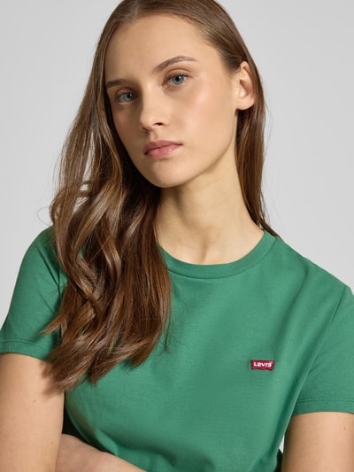 Vrouwenmodel draagt T-Shirt met Rundhalsausschnitt und Label-Stitching van Levi's®, groene kleur, pure katoen, regular fit, nahaufnahme bovenlichaam.