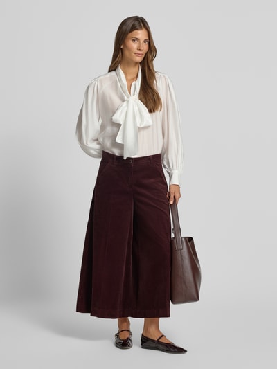 Frauenmodel trägt weinrote, weite Hose aus reiner Baumwolle Modell 'MELLI S' von Brax, kombiniert mit heller Bluse, Ganzkörperansicht von vorne, Damen Weite Hose von Brax.