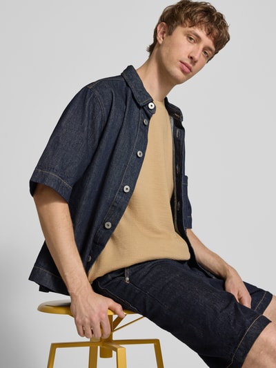 Männermodel trägt T-Shirt mit Strukturmuster und Rundhalsausschnitt Modell 'PETER' von Redefined Rebel, Baumwoll-Mix, Relaxed-Fit, beige, Rückenlänge bei Größe M 70 cm, Herren T-Shirt, Ganzkörperansicht von vorne.