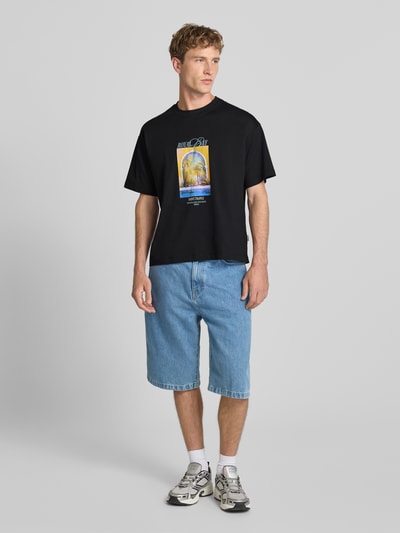 Männermodel trägt T-Shirt mit Motiv-Print Modell 'SANREMO' von JACK & JONES in Schwarz, Baumwolle, Regular Fit, Rundhalsausschnitt, Ganzkörperansicht von vorne
