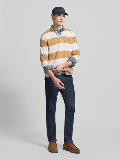 Männermodel draagt Sweatshirt mit Label-Stitching van Polo Ralph Lauren, puur katoen, regular fit, polokraag, knoopsluiting, ribboorden, ruglengte maat M 66 cm, mouwlengte 20 cm, gestreept in oker en wit. Ganzkörperansicht van voren.