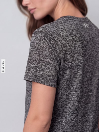 Frauenmodel trägt Loose Fit Sport-T-Shirt mit Logo-Print von Under Armour in Grau mit melierter Textur, Nahaufnahme Oberkörper, Damen Sport-T-Shirt von Under Armour, KI-modifiziertes Bild.