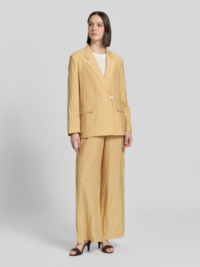 Frauenmodel trägt Straight Fit Blazer aus Viskose-Mix mit Strukturmuster von Jake*s Collection in Beige mit Reverskragen, Pattentaschen und Knopfverschluss, Leinen-Viskose-Anteil; Kombi mit passender Hose, Ganzkörperansicht von vorne. Brustweite, Rückenlänge und Ärmellänge bei Größe 36.