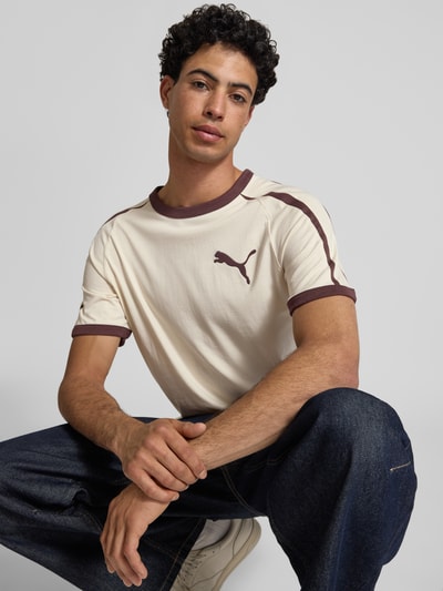 Männermodel trägt Regular Fit T-Shirt mit Logo-Print von PUMA PERFORMANCE, cremebraun mit Rundhalsausschnitt, Baumwolle, Nahaufnahme Oberkörper.