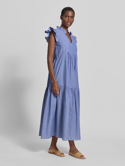 Vrouwenmodel draagt midi-jurk van puur katoen, loose fit, model 'Waldy Izha' met serafinokraag en mouwen met ruches van MOS MOSH, geheel in blauw, textuur met lichte plisé, modelinformatie: ruglengte maat S 131 cm, borstwijdte 42 cm, mouwlengte 11 cm, geheel lichaamsaanzicht van voren.