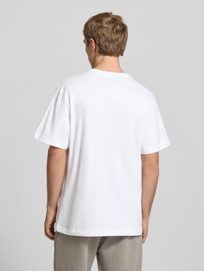 Männermodel trägt weißes T-Shirt mit Logo-Stitching von The North Face aus reiner Baumwolle, gerader Schnitt, Ganzkörperansicht Rückansicht.