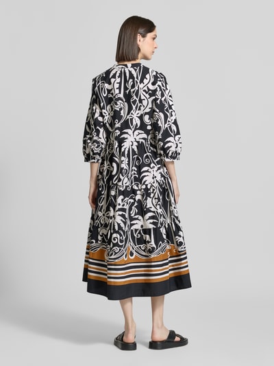 Frauenmodel trägt Midikleid mit Eingrifftaschen und 3/4-Arm von Emily Van den Bergh, Reine Baumwolle, A-Linie, Allover-Look, Rückenlänge 126 cm, Brustweite 43 cm, Ärmellänge 46 cm, Ganzkörperansicht Rückansicht.