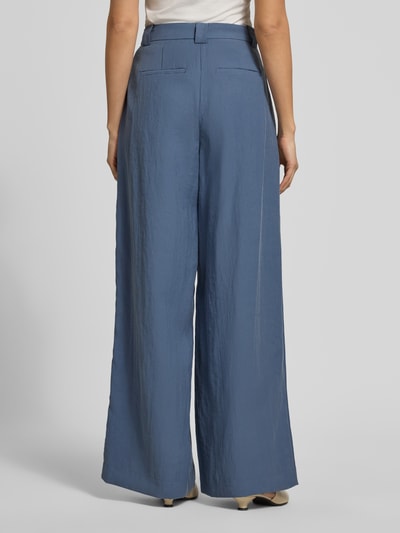 Frauenmodel trägt High Waist Hose aus Viskose-Mix Modell 'Frode' von MSCH Copenhagen in Blau mit weitem Bein und Hakenverschluss, Ganzkörperansicht Rückansicht. Damen Hose aus Viskose-Mix mit Bundweite 36 cm und Innenbeinlänge 79 cm bei Größe S.