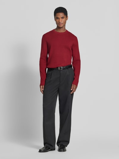 Mężczyzna nosi Slim Fit Strickpullover Baumwoll-Mix od Lindbergh, mieszanka bawełny, efekt prążkowania, okrągły dekolt, długość tyłu 70 cm, długość rękawów 72 cm, krój slim fit, Ganzkörperansicht von vorne.