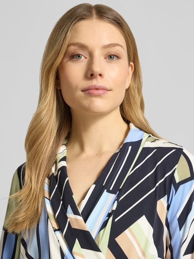 Modelka kobieca nosi Regular Fit Maxikleid in Wickel-Optik od Betty Barclay w geometryczne wzory, elastyczny materiał, szlafrokowy kołnierz, dekolt V, pasek, długość z tyłu 128 cm w rozmiarze 36, szerokość w rozmiarze 36: 31 cm, długość rękawa 46 cm, krój regular fit, zbliżenie na górną część ciała
