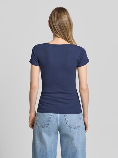 Frauenmodel trägt Slim Fit T-Shirt mit Logo-Applikation von Guess aus elastischem Baumwoll-Mix, Farbe Dunkelblau, Ganzkörperansicht Rückansicht.