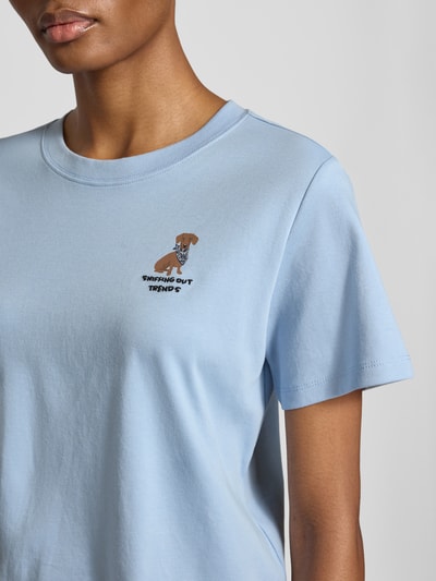 Kobieta nosi Regular Fit T-Shirt aus reiner Baumwolle von s.Oliver RED LABEL w jasnoniebieskim kolorze, subtelny nadruk, zbliżenie na górną część ciała.