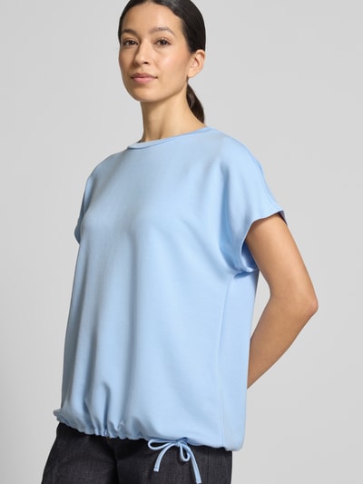 Frauenmodel trägt T-Shirt mit Rundhalsausschnitt von Soyaconcept in Hellblau, Regular Fit, Kappärmel, Tunnelzug, Material-Mix, Ganzkörperansicht von vorne.