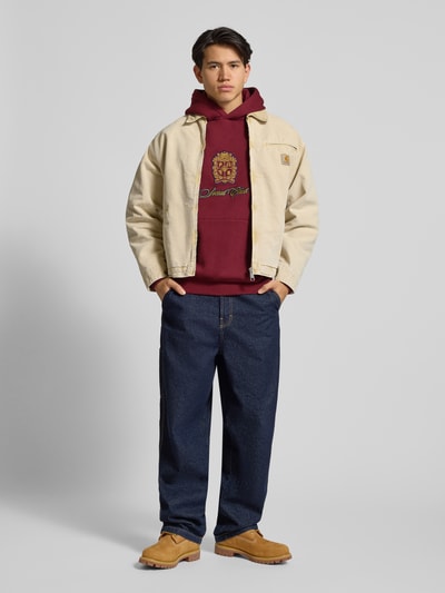 Männermodel trägt Hoodie mit Kapuze von PROHIBITED in Bordeaux, Baumwoll-Mix, Lockerer-Schnitt, Label-Detail, Känguru-Tasche, Gerippte-Abschlüsse, Ganzkörperansicht von vorne.
