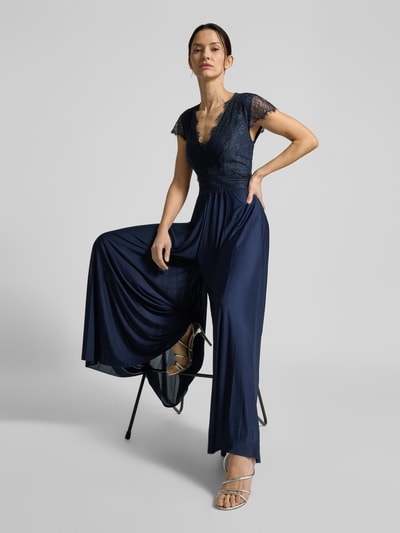 Modelka nosi granatową suknię wieczorową 'Abendkleid mit Spitzenbesatz Modell Emelie' od GUIDO MARIA KRETSCHMER WOMAN, koronka, głęboki dekolt V, taliowany krój, długość całkowita 148 cm, Szerokość w rozmiarze 36: 33 cm, długość rękawa 13 cm, podszewka kryjąca, widok całej sylwetki z przodu.