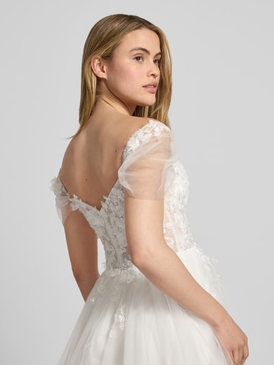 Frauenmodel trägt Brautkleid mit Herz-Ausschnitt von Luxuar, Taillierter Schnitt, Volants, Nahtreißverschluss, blickdichter Unterrock, Ganzkörperansicht Rückansicht.